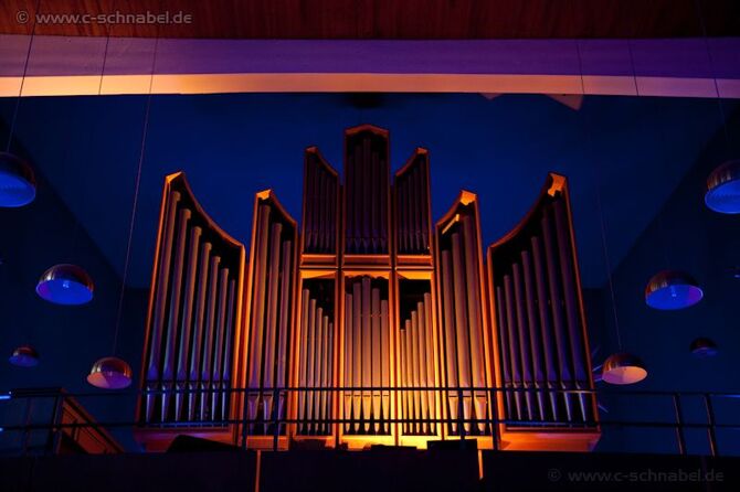 orange beleuchtete Orgel vor blauem Hintergrund